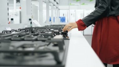 güzel genç kadın dükkanda yeni gaz sobaları bakar