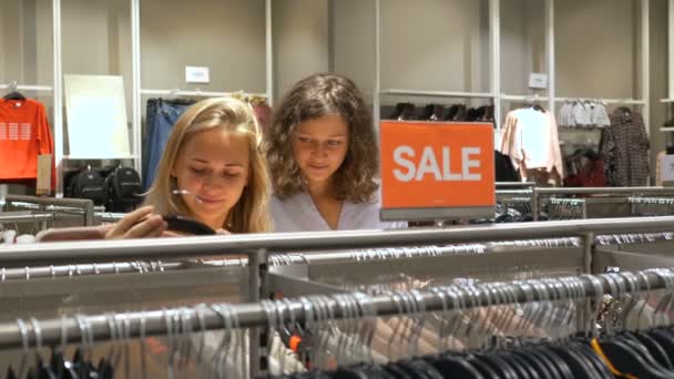Дамы проводят время в магазине и смотрят на порошкообразный свитер — стоковое видео