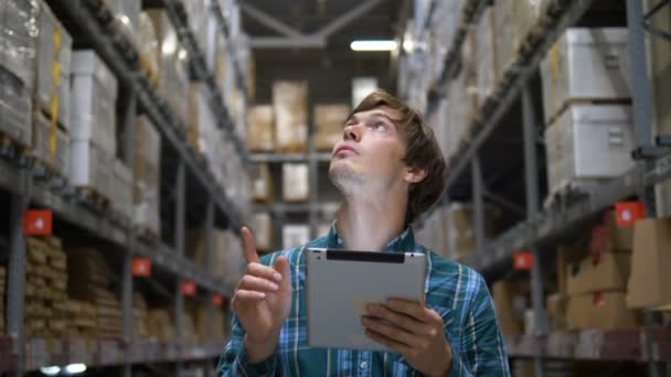 Homme regarde les étagères et saisit des informations sur les marchandises à tablette — Video