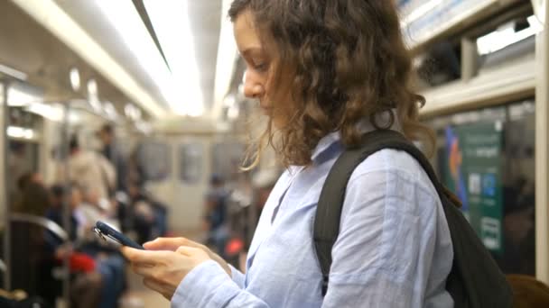 Girl surfs Internet standing in underground carriage — Stock Video