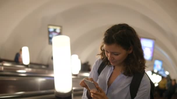 Дама читает сообщения и смотрит на подъем часов на эскалаторе — стоковое видео