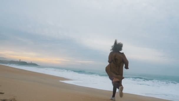 Girl traveler runs on sand shore enjoying amazing ocean surf — Stock Video