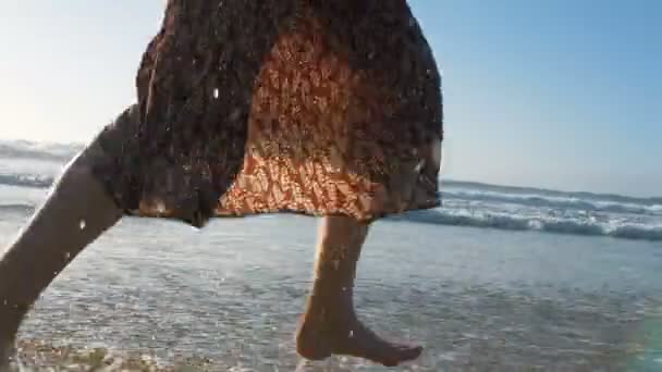 Kobieta cieszy się ciepłą wodą oceaniczną biegnącą wzdłuż krawędzi plaży — Wideo stockowe