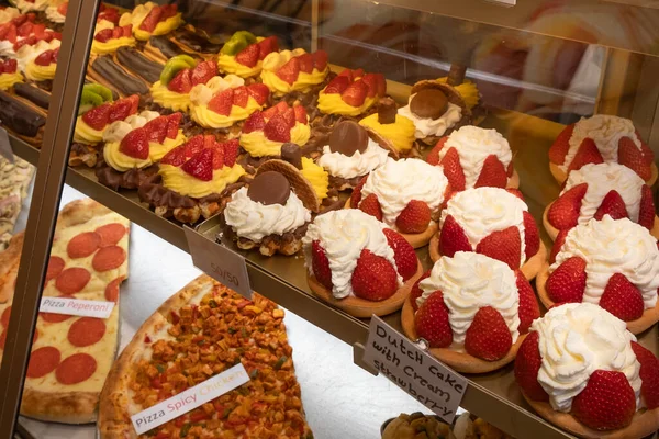 Friss, ízletes édes sütemények vannak az üvegablak mögötti boltban. — Stock Fotó