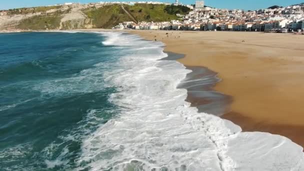 Vista superior ondas do oceano rolar na praia pela cidade velha perto de colinas — Vídeo de Stock