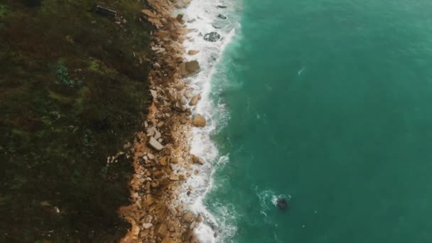 Movimento aereo da costa rocciosa collina attraverso la spiaggia alla città — Video Stock