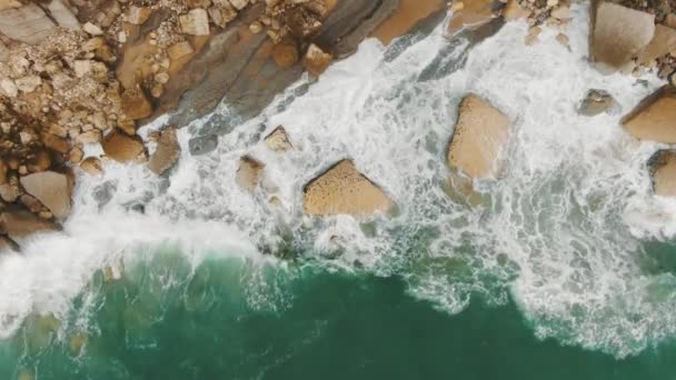 Vista superior de las olas del océano golpeando contra la costa rocosa — Vídeos de Stock