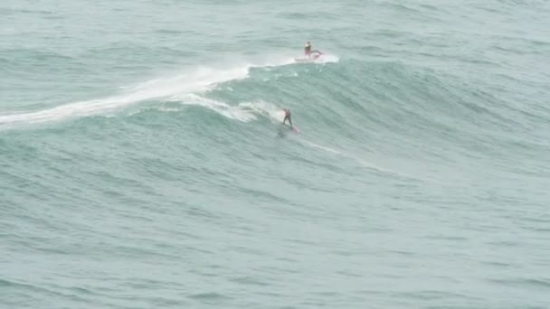 Chico activo surfea lejos de acercarse a enormes olas del océano — Vídeos de Stock