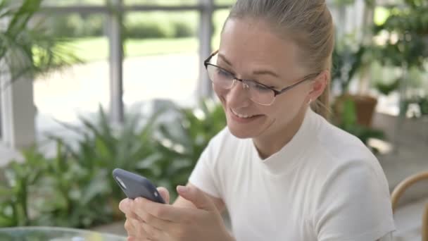 Geschäftsfrau mit Brille surft mit Smartphone im Internet — Stockvideo