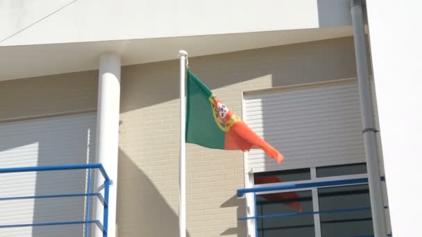 Σημαία της Πορτογαλίας κυματίζει στον άνεμο σε πόλο κατά την οικοδόμηση τοίχο — Αρχείο Βίντεο