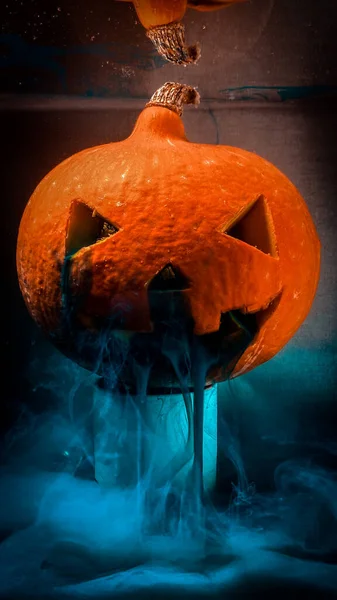 Halloween pumpkin in an aquarium with blue paint leaking out of its mouth — Stock Photo, Image