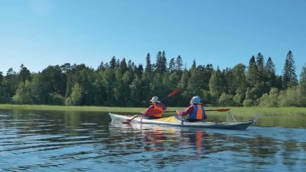 Man och kvinna i västar segla kajak längs lugna floden — Stockvideo