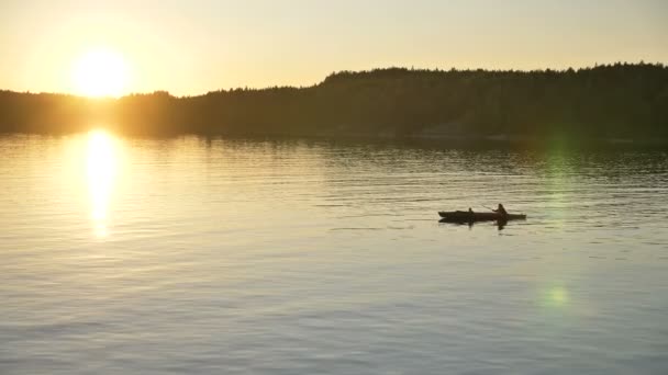 Silhuett av person med barn segling kajak längs sjön — Stockvideo