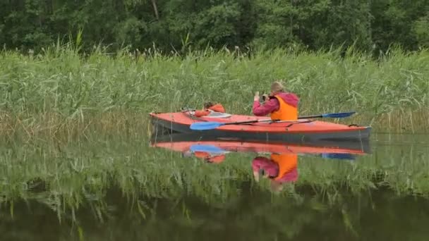 Wanita mengambil gambar berlayar kayak dengan gadis melalui alang-alang — Stok Video