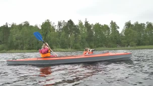 Mother rows kayak while daughter looks through binoculars — Stock Video