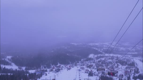 Stugor av linbana rör sig upp och ner över snöiga berg — Stockvideo