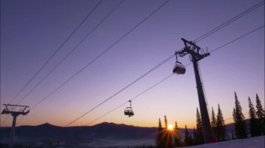 Karlı dağ yamacında hareket eden kamaraları olan kayak asansörü