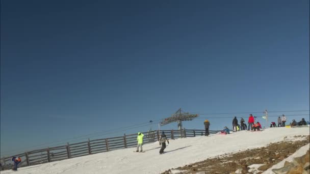 Turisté jezdit na lyžích a skateboardech podél zasněženého svahu — Stock video