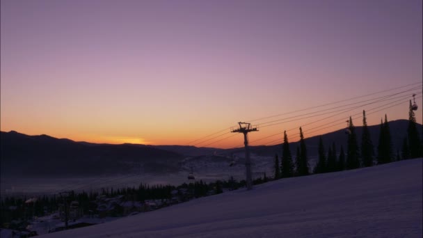 Silhouette di poma lift con cabine mobili sopra la collina innevata — Video Stock