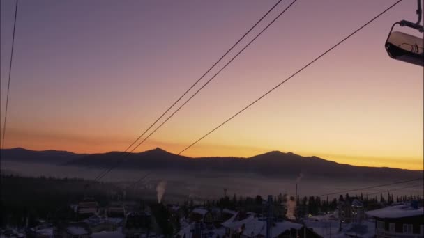 Hutten van poma lift bewegen over kleine stad op besneeuwde berg — Stockvideo