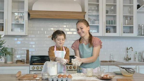 La figlia divertente e la madre fanno la pasta per torta a grande tavolo — Foto Stock