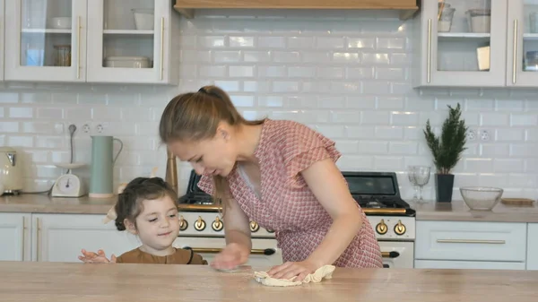 La donna pulisce il tavolo mentre la bambina corre in cucina — Foto Stock
