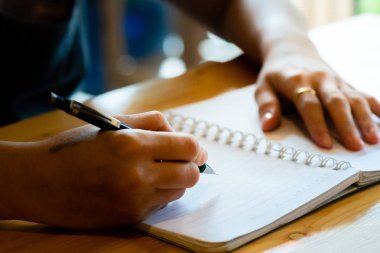 kahve dükkanında deftere kalem yazan kadın eli.kadın