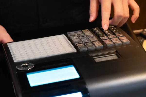 cash register installed on counter for accepting order from customer.sales man entering amount on electronic cash register in coffee shop and retail store.restaurant cashier typing on cash register.
