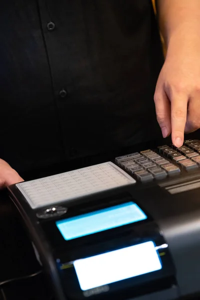 cash register installed on counter for accepting order from customer.sales man entering amount on electronic cash register in coffee shop and retail store.restaurant cashier typing on cash register.