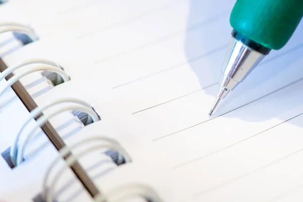 Vrouwelijke hand met potlood schrijven op notebook bij Coffee Shop. vrouw — Stockfoto