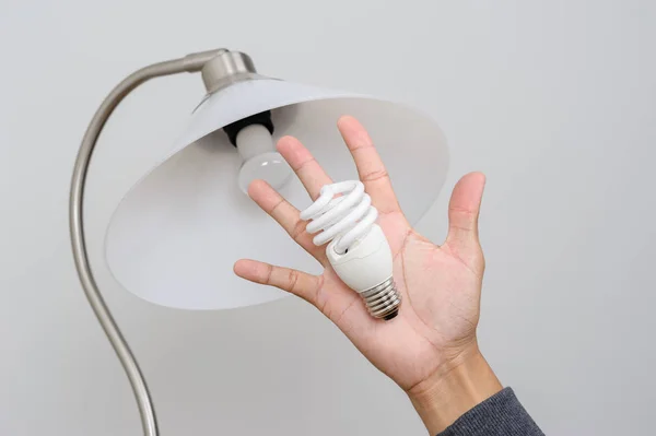 closeup hand changing an electric light bulb