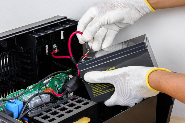 Technician replacing the UPS(Uninterruptible Power Supply) battery.