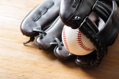 Tahtada beyzbol eldiveni olan çikolata rengi bir beyzbol eldiveni