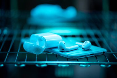Akıllı telefon ve kulaklıkların ultraviyole ışık sterilizasyonu. COVID-19 önleme kavramı.