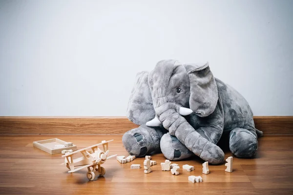 Niedliche Flauschige Elefantenpuppe Und Holzspielzeug Auf Dem Boden — Stockfoto