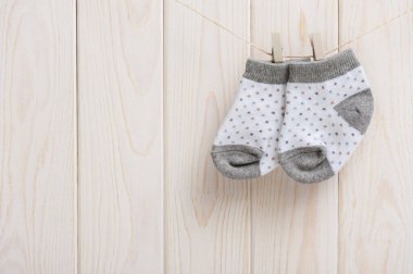 Yeni doğan bebek çorapları ahşap arka planda asılı duruyor, yeni doğan ve bebek konsepti