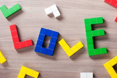 Renkli ahşap yapboz blokları oyuncakları, geometrik şekilli ahşap yapı taşları. Aşk kelimesi
