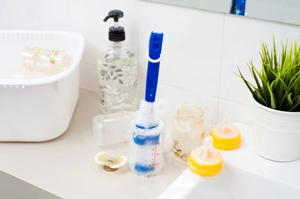 washing baby bottles and nipples with soft bottle brush and dishwashing liquid