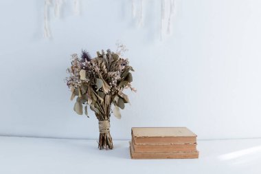 Beyaz arka planda kitapları olan kuru buket.