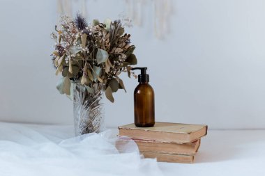 Okaliptüs 'ün arka planında bir kitapla kozmetik ürünleri