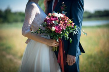 Gelin buketi, insanların ve doğanın arka planında pembe çiçekler.