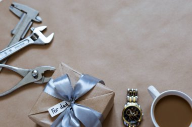 Bir fincan kahve, saat ve aksesuarla birlikte hediye paketi. Babalar Günü için masanın üzerinde onarım için.