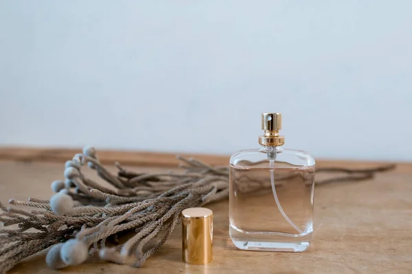 Parfüm Auf Einem Holztisch Mit Einer Trockenen Blume Auf Weißem — Stockfoto