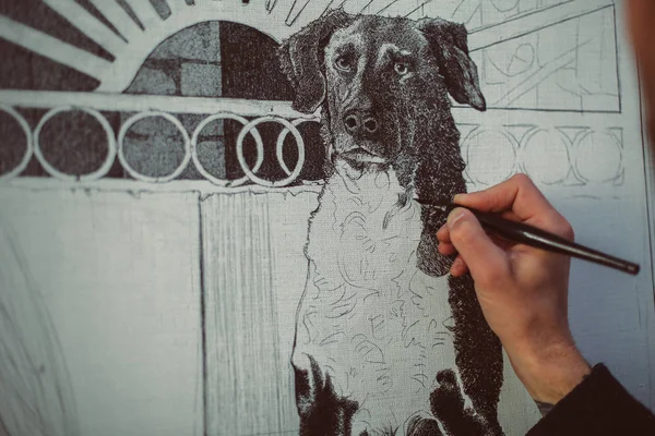 Man\'s hand drawing a dog