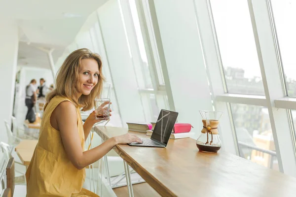 うれしそうな女性はコーヒーを飲むと作業 — ストック写真