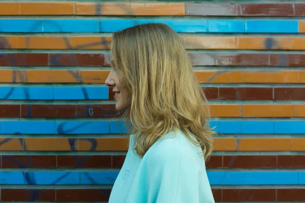 Perfil de mujer cerca de colorido muro al aire libre — Foto de Stock