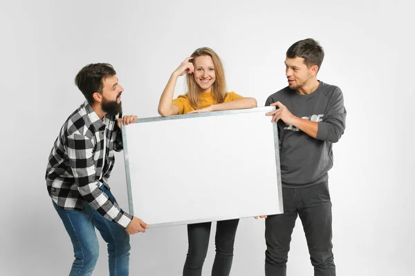 Young people holding white board — Stock Photo, Image