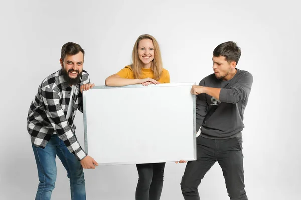 Young people holding white board