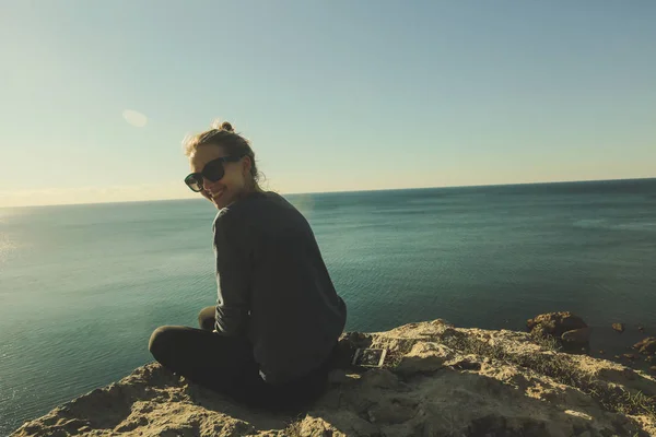 Boldog lány a sziklás szélén a tenger közelében — Stock Fotó
