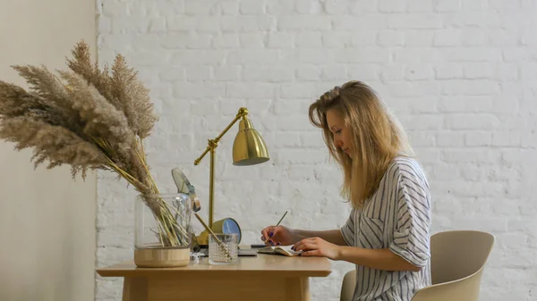Женщина пишет почерком за столом — стоковое фото